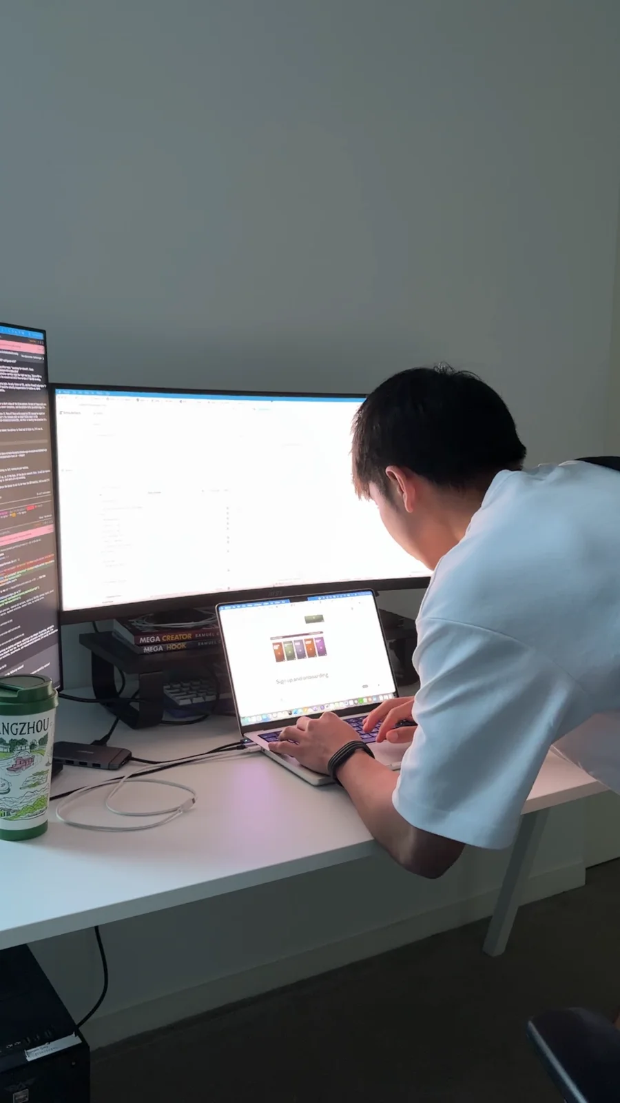 Dayrent working at a desk with a laptop and two monitors