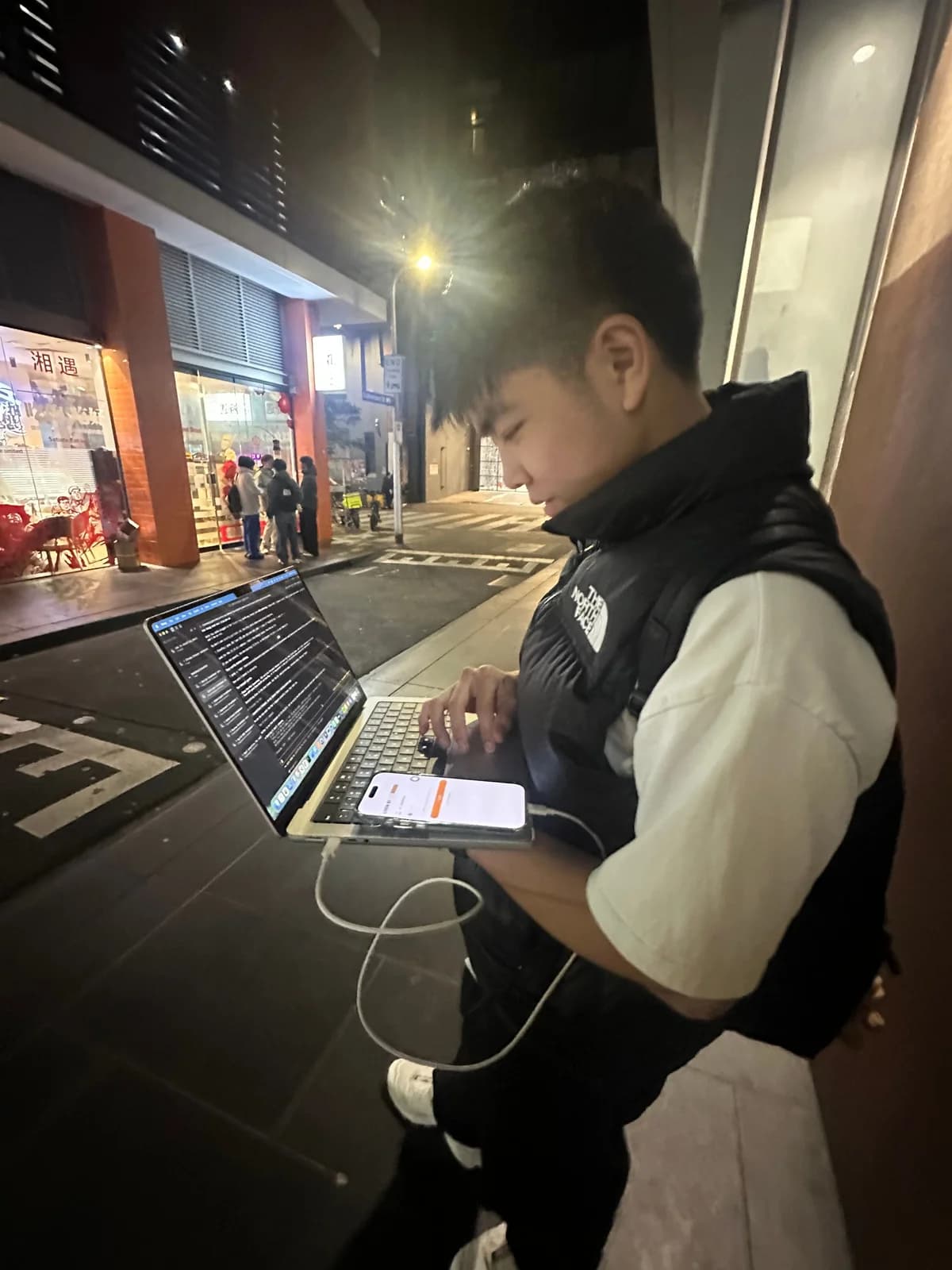 Dayrent working on a laptop outdoors at night